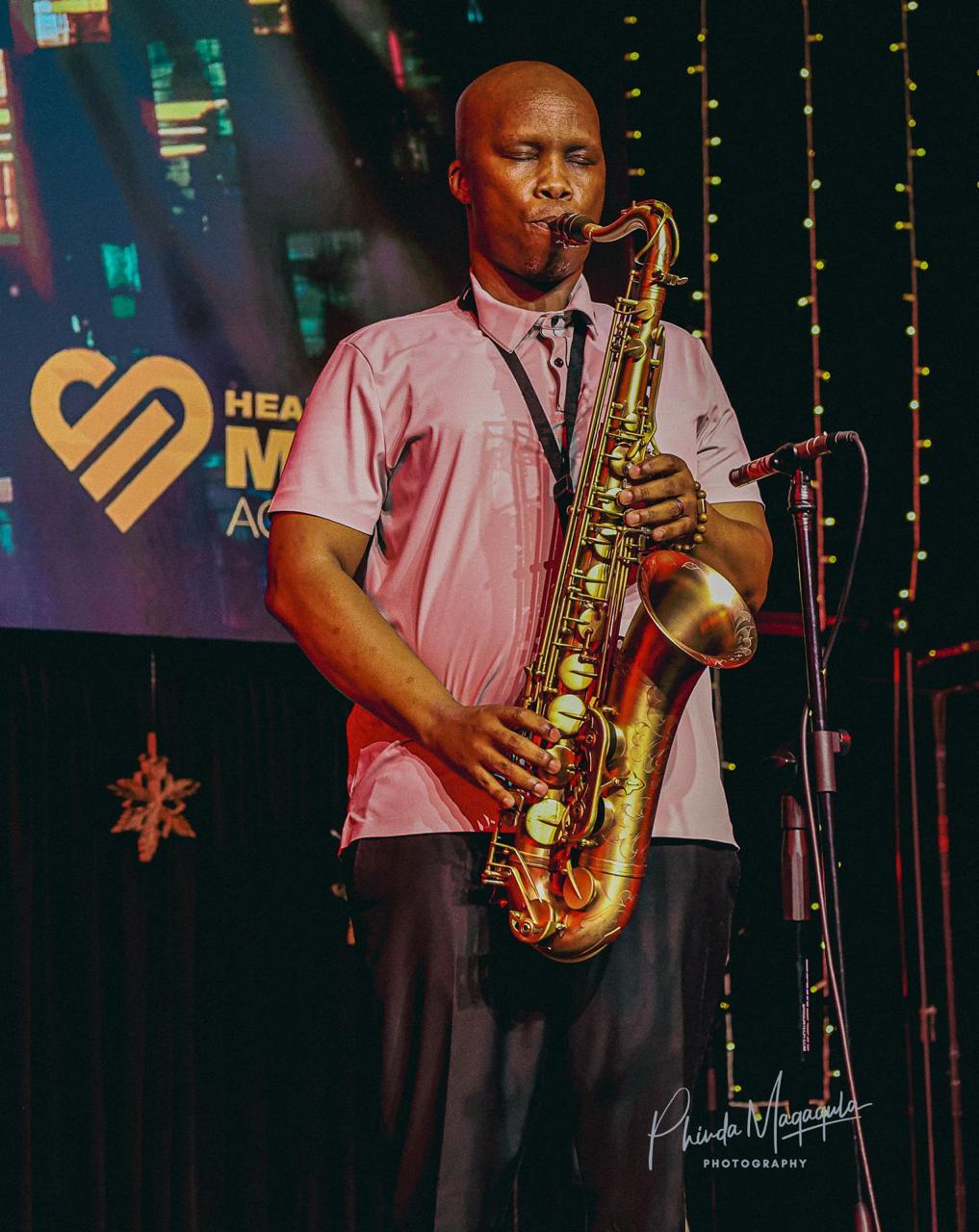 Saxophonist performing on the Heart Songs Music Academy stage